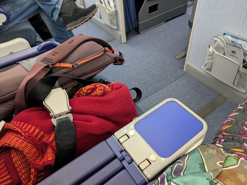 The empty airplane seat next to us, with our bags and coats