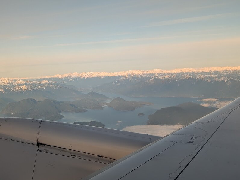 Islands in an inlet, with high snow-capped mountains beyond.